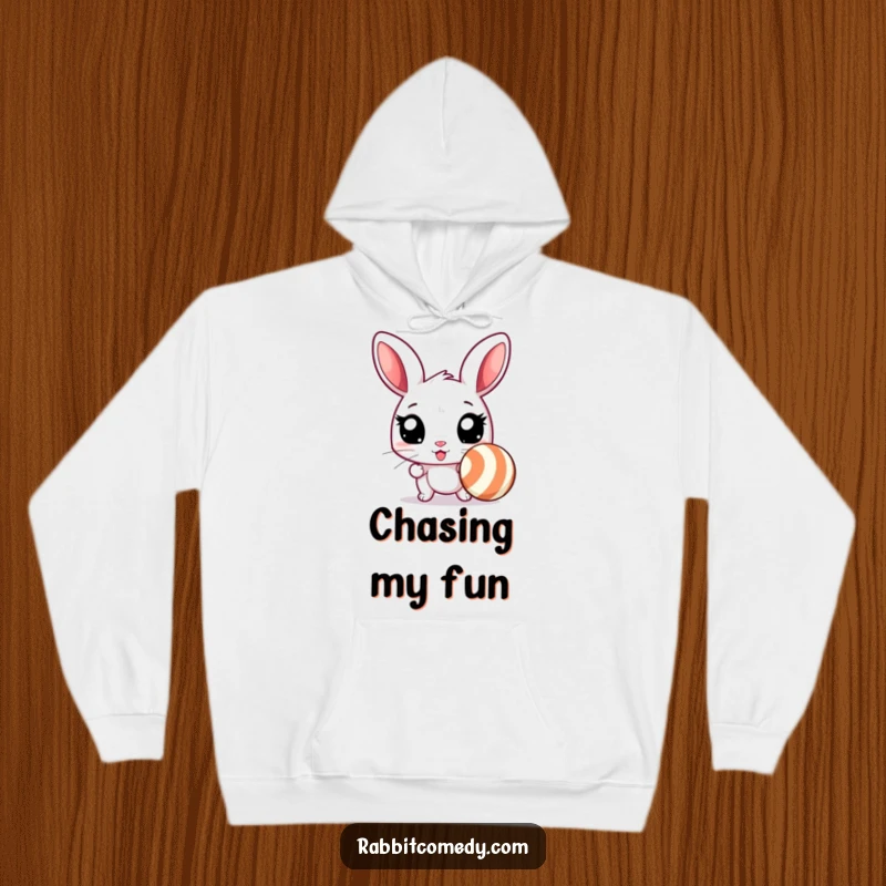 Funny rabbit hoodie featuring an excited rabbit with wide eyes, poised to chase a bouncing, striped ball, embodying humorous energy.
